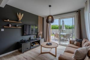 a living room with a couch and a table at la maison du bord de mer in Penvénan