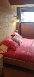 a bedroom with a bed with red sheets and a window at Chalet-nature in Bolquere Pyrenees 2000