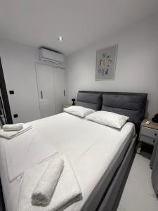 a bedroom with a large white bed with a remote control on it at kallithea maisonette in Kallithea Halkidikis +16 photos
