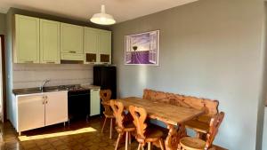 a kitchen with a wooden table and some chairs at Casa Feliciani - MonferratoHome in Viarigi
