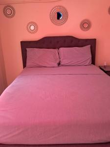 una camera con letto rosa e cuscini rosa di Meca a Portmore