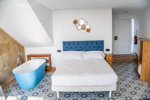 a bedroom with a bed and a bath tub at O da Sina-Los refugios del capitán COTE in Aldán +11 photos