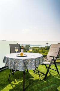 a table with two glasses of wine and two chairs at O da Sina-Los refugios del capitán COTE in Aldán