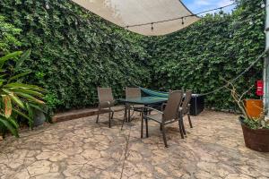 un patio con mesa, sillas y seto en Casa Encanto - 3Bdr, 2.5bath w/Jacuzzi and Parking, en Puerto Vallarta