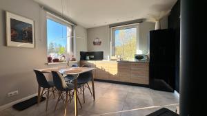 a kitchen with a table and chairs and a counter at Apartamenty Karkonoska Polana in Staniszów
