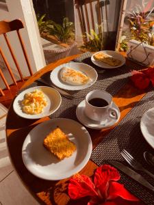 a table with plates of food and a cup of coffee at Shalon Adonai by Martinelli Lodge in Fernando de Noronha