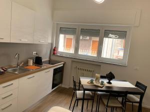 una cucina con tavolo, sedie e lavandino di Pizzoli Suite a Bari Altre 10 foto