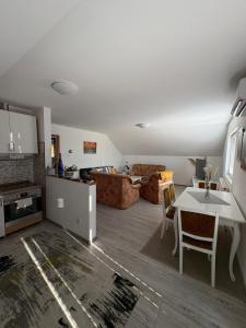 a living room with a table and a couch at Apartman Salus in Tuzla