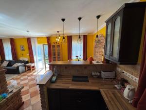 sala de estar con cocina con paredes amarillas en MIMÓZA Nyaralóház, en Tiszafüred