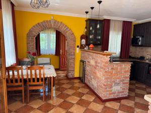cocina con chimenea de ladrillo, mesa y sillas en MIMÓZA Nyaralóház, en Tiszafüred