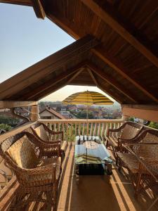 a patio with chairs and a table and an umbrella at Apartman Salus in Tuzla