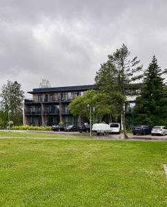 a large building with cars parked in a parking lot at Albatross Loft in Ķesterciems