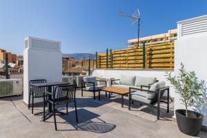 a patio with chairs and tables on a roof at Urban Oasis in Fuengirola
