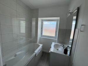 Un baño blanco con bañera y lavabo. en Logement proche Aéroport Nantes, en Saint-Aignan-Grand-Lieu 14 fotos más