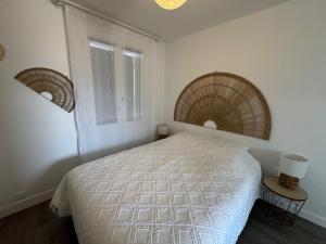 Un dormitorio con una cama blanca y dos ventanas. en Logement proche Aéroport Nantes, en Saint-Aignan-Grand-Lieu