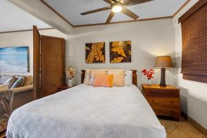 a bedroom with a bed and a ceiling fan at Direct Oceanfront Beach Pohailani Studio - New in Kahana