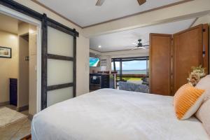 a bedroom with a large bed and a sliding glass door at Direct Oceanfront Beach Pohailani Studio - New in Kahana +32 photos