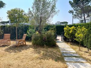 un jardin avec deux chaises et quelques buissons dans l'établissement San Pietro Resort -Luxury garden apartment Gjiri I Lalezit, à Lalzit Bay