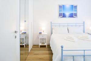 Un dormitorio blanco con una cama y un espejo. en Rossini Lifestyle, en Fano