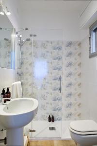 Un baño con lavabo, inodoro y ducha. en Rossini Lifestyle, en Fano 11 fotos más