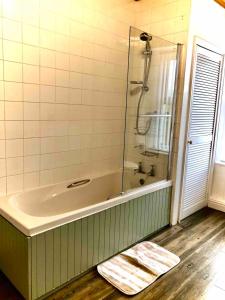 a bathroom with a shower and a bath tub at The MireHouse - Georgian rural retreat in Ullock