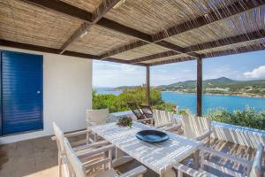 a table and chairs on a patio with a view of the ocean at Hidesign Athens Villa In Sounio in Sounio