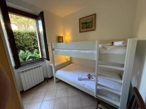 Zimmer mit 2 Etagenbetten und einem Fenster in der Unterkunft Casa Lago in Bellagio in Bellagio