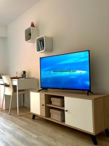 a living room with a flat screen tv on a cabinet at Happy studio Orient bay Palm court Residence in Orient Bay