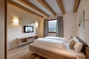 a bedroom with two beds and a tv on the wall at Resort Tirol Brixen am Sonnenplateau in Brixen im Thale