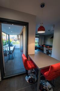 una cocina con mesa y taburetes rojos en La Prairie, en Annecy