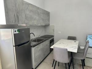a kitchen with a refrigerator and a table with chairs at Meca 2025 Apartments in (( Barç ))