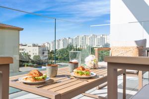 twee borden met eten op een houten tafel op een balkon bij Casa Del Toro Estepona in Estepona