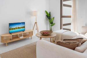 een woonkamer met een bank en een tv op een tafel bij Casa Del Toro Estepona in Estepona +20 foto's