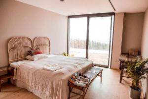a bedroom with a large bed and a large window at Moderne Sea View Villa mit Pool in Santo Isidoro