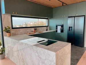 a large kitchen with green cabinets and a large window at Moderne Sea View Villa mit Pool in Santo Isidoro