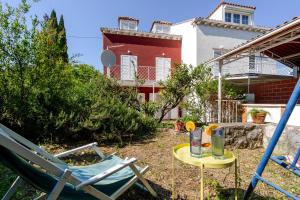 a patio with a table and chairs and a house at Holiday Home Mareta in Dubrovnik