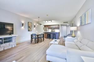 un salon avec un canapé blanc et une table dans l'établissement Highland Hideaway 1BR King Suite, à Shanty Bay