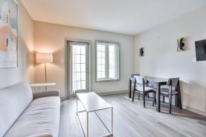 un salon avec un canapé et une table dans l'établissement Highland Hideaway 1BR King Suite, à Shanty Bay