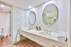 une salle de bain avec deux lavabos et deux miroirs dans l'établissement Highland Hideaway 1BR King Suite, à Shanty Bay