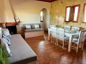 a dining room with a table and chairs and a couch at Anatèlia Beach House in Portianón +30 photos