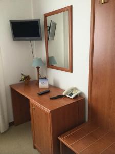 Zimmer mit einem Schreibtisch, einem Telefon und einem Spiegel in der Unterkunft Hotel Ristorante da Toni in Codevigo