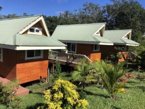 a house with a green roof at Kikala Waterfall Lodge in Hilo