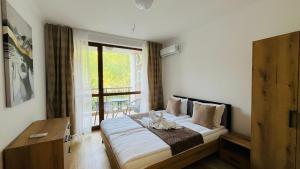a bedroom with a bed and a balcony with a table at ASTORIA II Apartment 24 One Bedroom in Elenite +35 photos