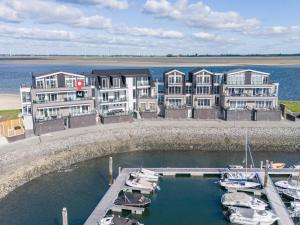 a group of buildings with boats in a marina at Penthouse in Sint-Annaland by the Beach in Sint Annaland
