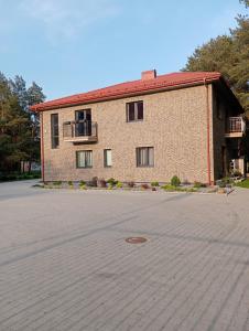 a large brick building with a large parking lot at 4 winds Eurus in Palanga
