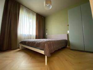 a bedroom with a bed in front of a window at 4 winds Eurus in Palanga