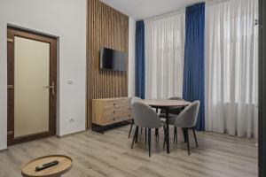 a dining room with a table and chairs and a television at Interbelic Villa close to Old Town in Bucharest