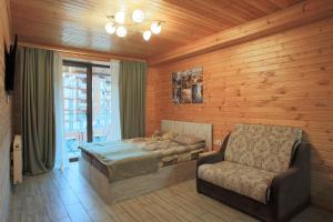 a bedroom with a bed and a couch and a chair at New Gudauri Rooms in Gudauri