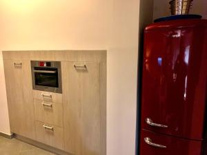 a red refrigerator in a kitchen with a microwave at Les lauriers du loft in Pazayac