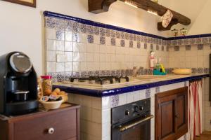 a kitchen with blue and white tiles on the wall at Agriturismo La Stornara, Petfriendly & EV Friendly in Ginosa Marina